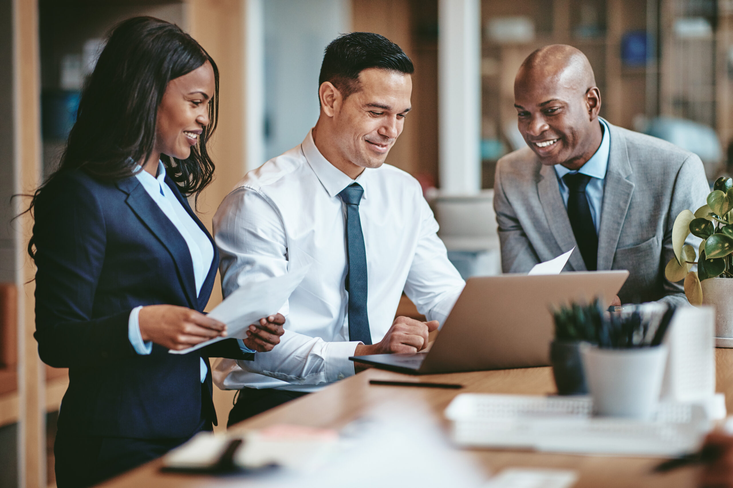 Three employees working together and reviewing business information