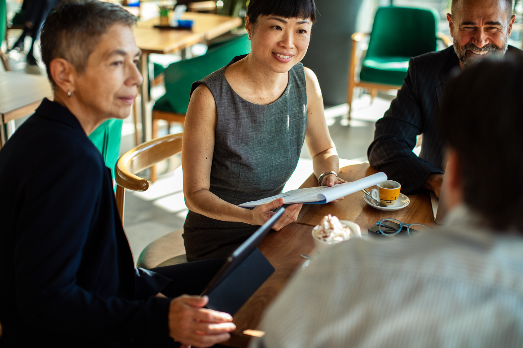 Employees eating and drinking together while discussing business