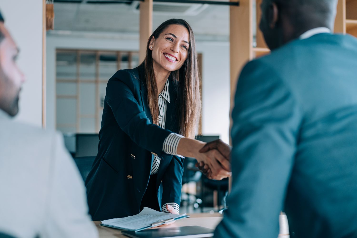 Man and woman shaking hands in business environment