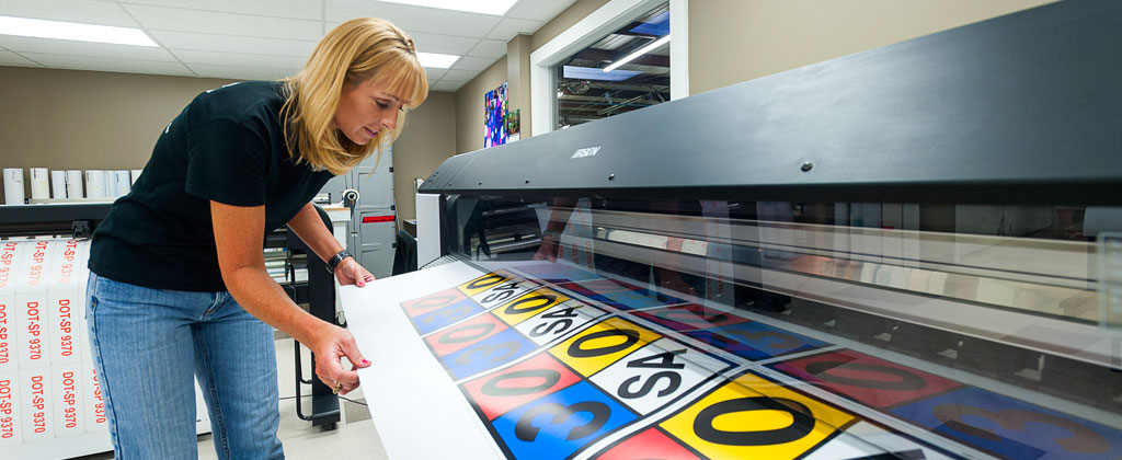 Woman using wide format printer
