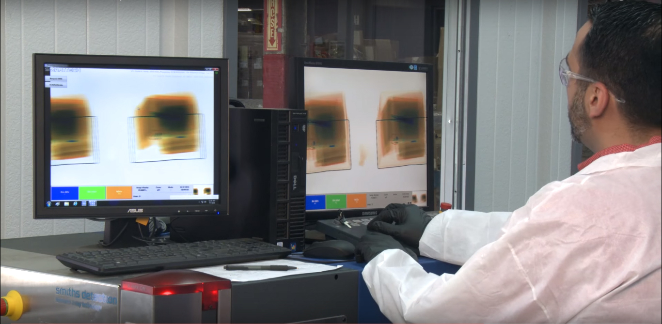 Man sitting at computer conducting mail screening process for business security