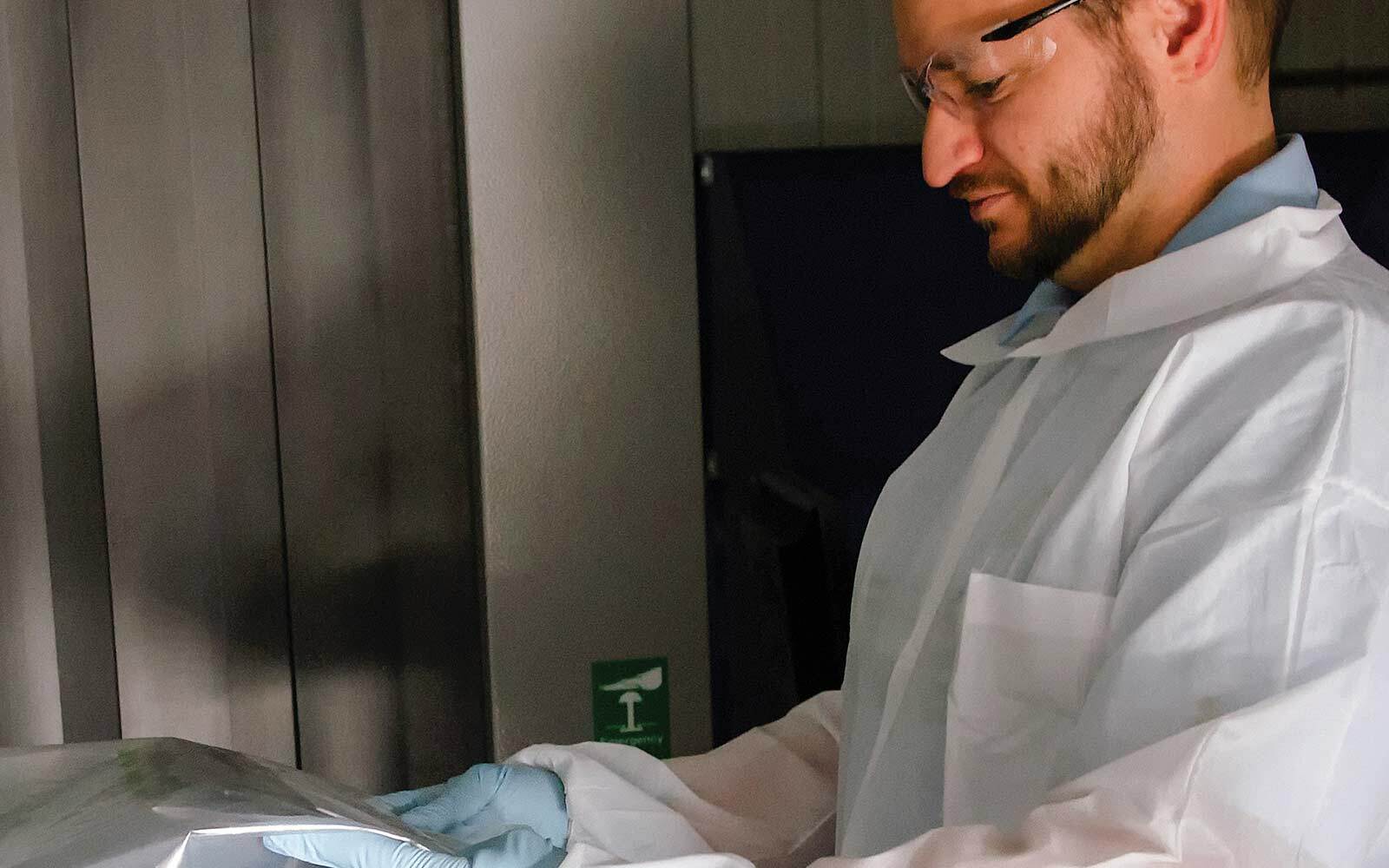 Man with protective coat and goggles inspecting mail