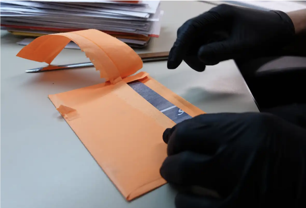 On-Site Screening - gloved person inspecting mail for potential threats