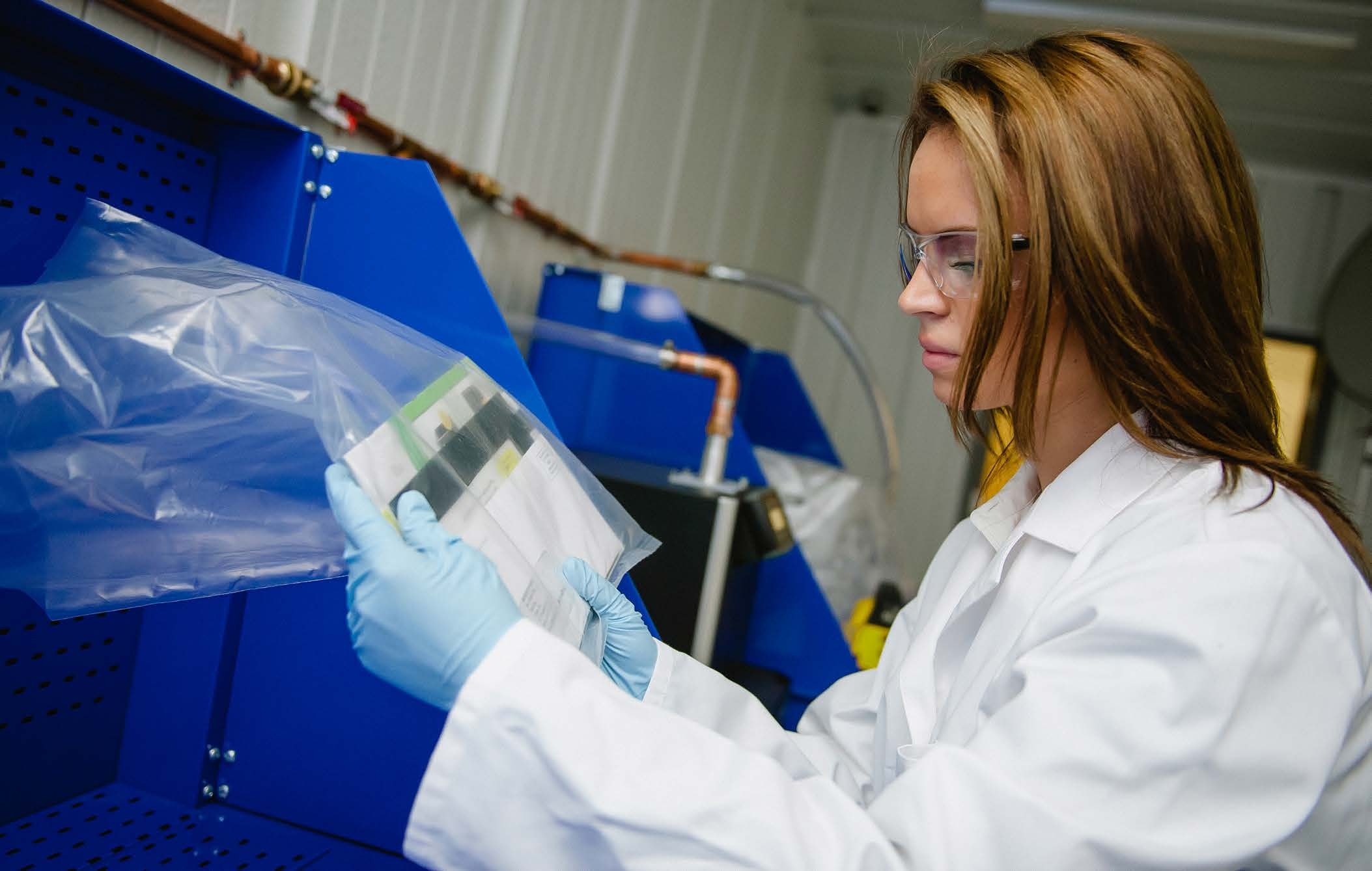 Woman screening mail in a plastic bag for potential threats